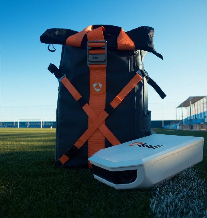 A Hudl Focus Flex backpack with a camera sitting beside it